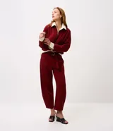 Pantalón de corte barrel color bordó, confeccionado en algodón con felpa. Presenta cintura alta con cinto incorporado y hebilla metálica, con diseño estructurado y piernas anchas.