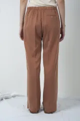 Pantalón marrón de corte recto con pinzas en la cintura.