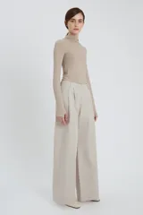 Pantalón de corte ancho (relaxed fit) color gris claro, con pinzas frontales y efecto lavado sedoso.