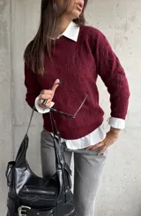 Sweater de punto color bordó con diseño de bordado floral en relieve, cuello redondo y mangas largas con puños acanalados.