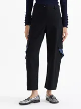 Pantalón de gabardina color marrón, de tiro alto y silueta estructurada. Cuenta con volados de denim azul aplicados sobre los bolsillos plaqué laterales y bolsillos plaqué traseros con remache dorado.