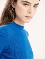 Polera negra de tejido de punto acanalado, con cuello alto y mangas largas.