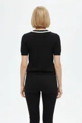 Remera de algodón al cuerpo en color negro, con mangas cortas y cuello redondo adornado con cordón blanco.