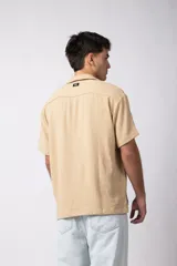 Camisa de manga corta color negro, con cuello cubano y botones frontales. Tejido de lino con textura entramada.