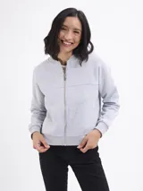 Campera tipo bomber de felpa color gris claro, con cierre frontal completo, cuello redondo y puños elásticos acanalados.