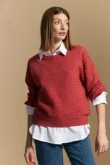 Sweater color crema con mangas abullonadas y puños elastizados. Presenta una textura tejida en relieve con patrón de ladrillos en el cuerpo y rayas horizontales en las mangas.