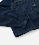 Campera de jean color azul oscuro, con diseño cropped, cuello clásico, mangas largas, cierre frontal con botones y dos bolsillos frontales grandes.