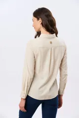 Camisa de lino lisa de manga larga, con cuello clásico y cierre frontal de botones.