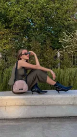 Bandolera pequeña de diseño moderno, confeccionada en tafeta liviana y resistente. Cuenta con cierre superior, correa ancha ajustable y logo frontal de la marca.