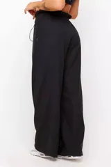 Conjunto deportivo de dos piezas compuesto por un buzo cropped de cuello alto con cordón ajustable y un pantalón estilo clochard de corte holgado con cintura elástica regulable y bolsillos laterales. Ambas prendas están confeccionadas en tejido técnico ligero con acabado suave al tacto.