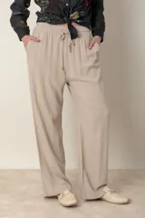 Pantalón ancho color beige de lino y rayón, con cintura elastizada ajustable con cordón y bolsillos laterales.