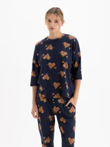 Remera de tejido flamé color azul marino con estampado de corazones con flechas en tonos marrones. Presenta cuello redondo y mangas tres cuartos con un corte holgado.