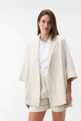 Blazer negro de corte recto y holgado, con doble botonadura frontal, solapas clásicas y mangas tres cuartos con costuras pespunteadas en contraste.