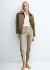 Pantalon de corte skinny en color beige, confeccionado en mezcla de algodón. Presenta un diseño crop con botones decorativos en la parte frontal, cierre oculto de cremallera y gancho, bolsillos laterales y bolsillos de ribete en la parte posterior.