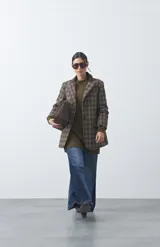 Blazer de corte relajado con estampado de cuadros tipo pied de poule en tonos rojizos y verdes. Presenta solapas clásicas en color azul oscuro y estructura definida.