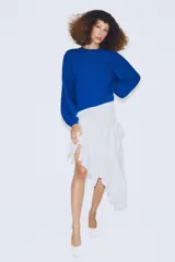 Jersey de punto color azul, con cuello redondo, mangas largas amplias y costuras marcadas en el frente.