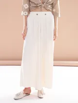 Pantalón palazzo color blanco con cintura alta y dos botones decorativos.