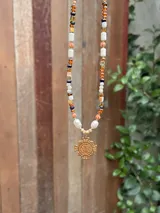 Collar de cuentas de cristales y perlas de río con dije dorado de cruz de San Benito.