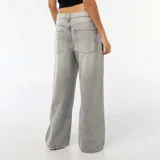 Jean de corte baggy y tiro bajo, color gris con efecto lavado y detalles de roturas en las piernas. Cuenta con diseño clásico de cinco bolsillos y cierre frontal con botón y cremallera.