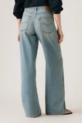 Jeans de corte recto y tiro alto, con diseño de pierna ancha y acabado lavado en tono celeste claro. Presentan cierre frontal con botón y cremallera, además de bolsillos laterales y traseros.