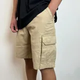 Bermuda cargo de gabardina color beige, con bolsillos laterales con solapa y bolsillos frontales tipo ojal.