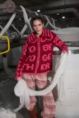 Cárdigan tejido de lana color borgoña con bordado de letras rosas que forman la frase "Good To Be Together". Tiene cuello redondo, cierre frontal con cremallera y calce holgado.