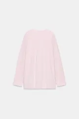 Camiseta oversize de manga larga color rosado, con cuello redondo y bajo recto.