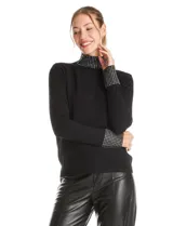 Polera de tejido soft color negro, con cuello alto y puños decorados con apliques de strass. Presenta un diseño de manga larga y corte ajustado.