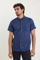 Camisa azul de manga corta, con cuello abotonado y bolsillo en el pecho.