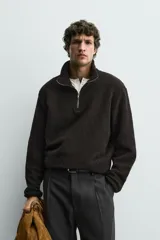 Sudadera de corte regular confeccionada en tejido de borreguillo con textura, cuello subido con cierre frontal de cremallera y manga larga con acabados en cinta.