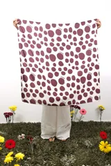 Pañuelo cuadrado de poliéster y elastano, de 1x1 metro, con estampado de lunares irregulares color bordó sobre fondo blanco y la palabra "CAPER" repetida en el diseño.