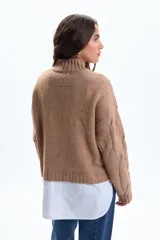 Sweater de punto en color beige con diseño de trenzas verticales, cuello alto acanalado y mangas largas con puños ajustados.