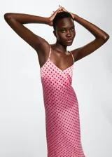 Vestido midi de tejido satinado en color rosado con estampado de lunares marrones. Presenta un diseño recto, cuello escotado y tirantes finos dobles que se cruzan en la espalda abierta.