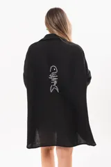 Vestido camisero corto negro, con escote en V, cuello clásico, mangas tres cuartos regulables y detalle de pez bordado a mano en la espalda.
