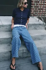 Jeans de tiro alto con pernera ancha, diseño cropped y estampado de lunares, con cinco bolsillos y cierre frontal de cremallera y botón metálico.