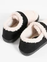Pantuflas marrones con interior de corderito color crema y ajuste con velcro.