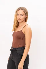 Body de tiras finas con escote redondo, confeccionado en tela elástica alicrada. Diseño ajustado al cuerpo sin broche en la parte inferior.