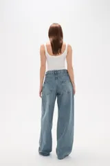 Pantalon de jean azul de corte ancho y tiro medio, con diseño de cinco bolsillos y cierre frontal con botón y cremallera.