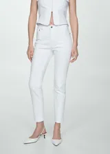 Jeans de corte slim y tiro medio en color blanco, confeccionados en denim de algodón elástico con diseño de cinco bolsillos, trabillas para cinturón y cierre frontal con cremallera y botón.
