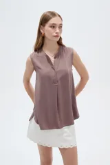 Blusa evasé de viscosa color blanco, sin mangas, con cuello a la base y escote en V con cartera frontal.