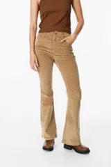 Pantalón de jean tipo pana color negro, de corte acampanado y tiro medio, con cierre frontal y bolsillos laterales.