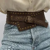 Cinto faja ancho de cuero genuino color tostado, con diseño de tachas metálicas decorativas y hebilla de metal envejecido.