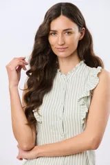 Musculosa de lino rayada con cuello mao y volados en los hombros. Presenta diseño de rayas verticales y aplique de etiqueta con logo en la parte posterior.
