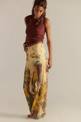 Pantalón de jean recto tiro medio color amarillo, con estampado artístico que incluye girasoles, peces y olas.