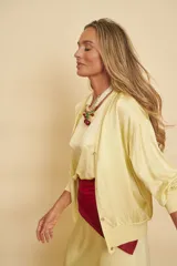 Cardigan de punto color amarillo claro, con mangas largas abullonadas y puños elásticos acanalados.