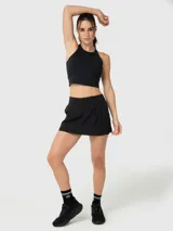 Top deportivo de sujeción media, color negro, con diseño de cuello alto y espalda cruzada. Confeccionado con tecnología Aloe Vera para mayor suavidad.
