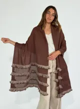 Chal marrón con diseño calado y flecos en los bordes.