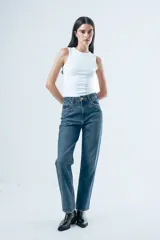 Jean de tiro alto con corte de pierna recta y diseño clásico de cinco bolsillos. Confeccionado en denim de tono azul medio con costuras en contraste.