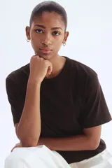 Remera de punto suave color negro, de algodón y viscosa, con hombros apenas caídos y cuello redondo.