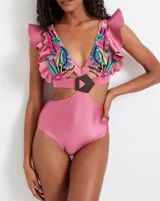 Traje de baño entero rosa con bordado floral multicolor, volados en los hombros y abertura en la cintura con hebilla geométrica.